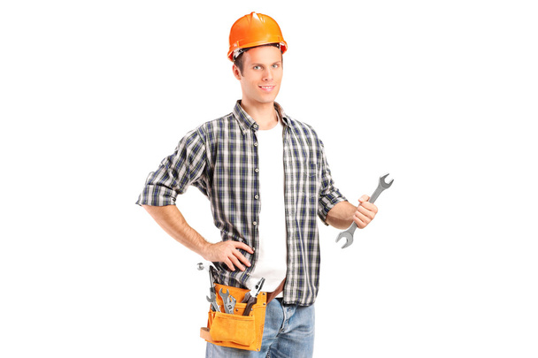 A confident and smiling handyman holding a wrench - Valokuva, kuva