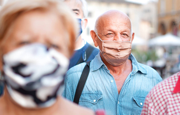 Tömegek sétálnak a város utcáin maszkban - Fényképezőgép fókuszáló egy idős ember - Új életmód - Fotó, kép