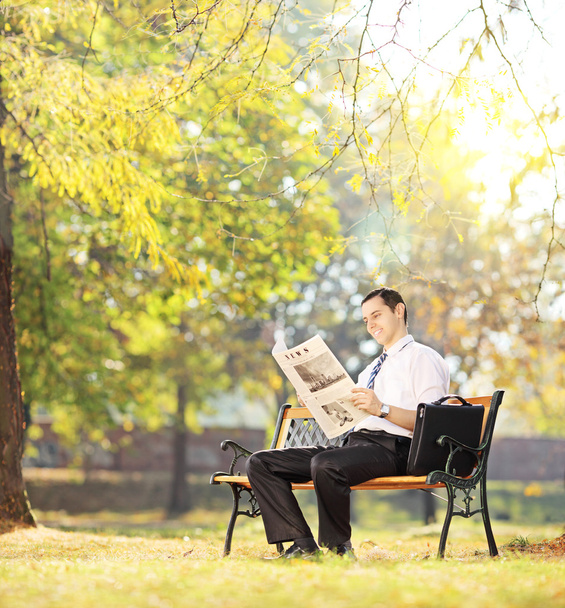 公園で新聞を読んでいる人 - 写真・画像