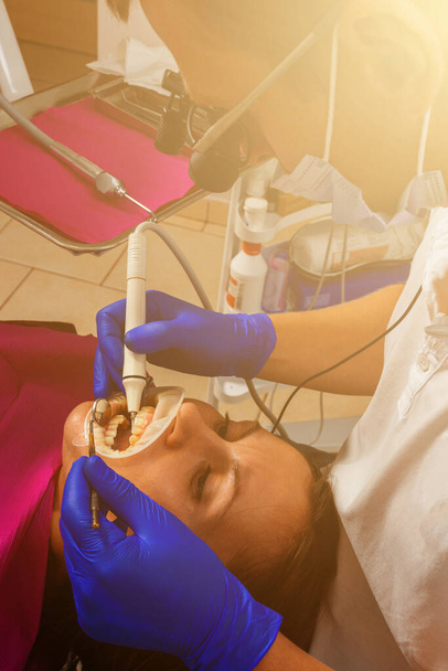 Op afspraak van de tandarts, het verwijderen van tandsteen, het gebruik van echografie, patiënt en tandarts.2020 - Foto, afbeelding