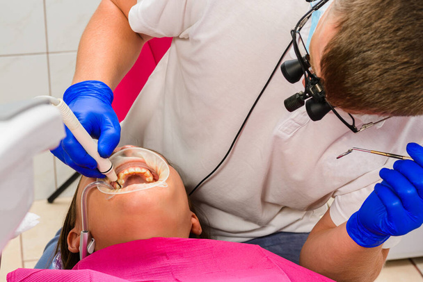 Der Zahnarzt benutzt einen Scaler, um Zahnstein zu entfernen, Mundhygiene.2020 - Foto, Bild