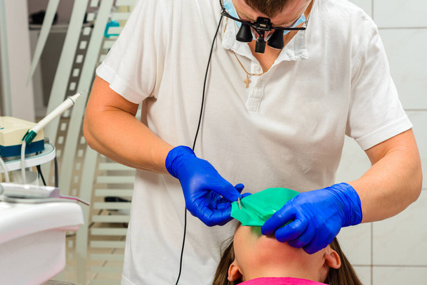 Установка гумової греблі з металевим затискачем для зубних пломб, стерильне і сучасне стоматологічне лікування. 2020
 - Фото, зображення