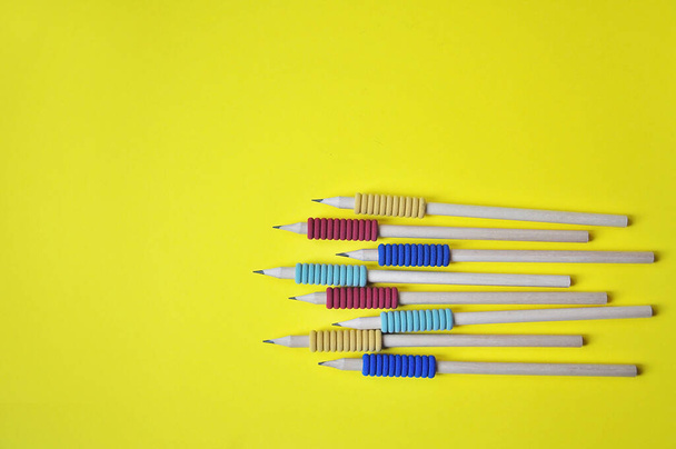 gekleurde potloden met een zachte gekleurde pad voor correct schrijven. het concept van voorbereiding op school en studeren - Foto, afbeelding