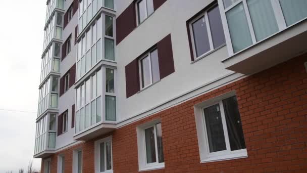 En la pared del nuevo edificio residencial hay balcones y ventanas de apartamentos - Imágenes, Vídeo