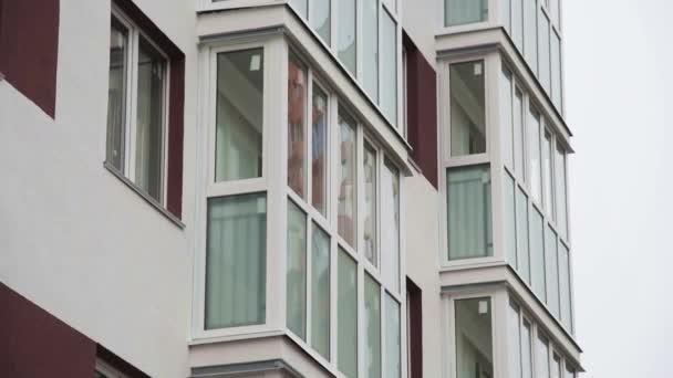 Aan de muur van het nieuwe woongebouw zijn er balkons en ramen van appartementen - Video