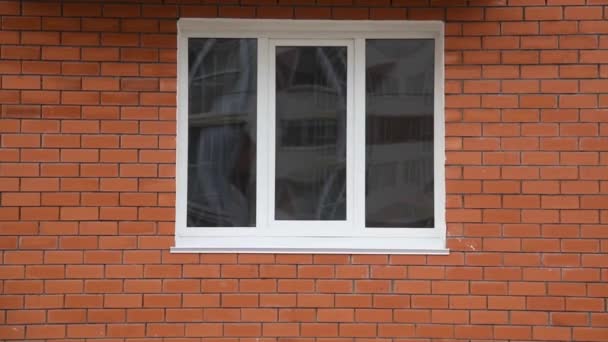 Ένα παράθυρο στον τοίχο ενός νέου κτιρίου διαμερισμάτων - Πλάνα, βίντεο