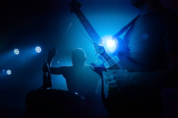 Banda tocando en vivo durante el concierto, concierto. Siluetas de guitarrista y baterista - Foto, imagen