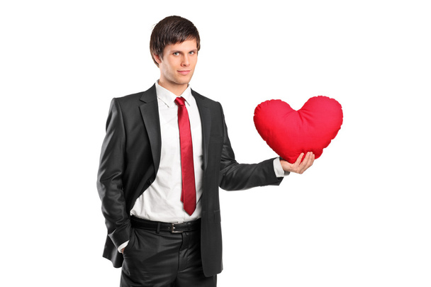 Man holding heart shaped pillow - Zdjęcie, obraz