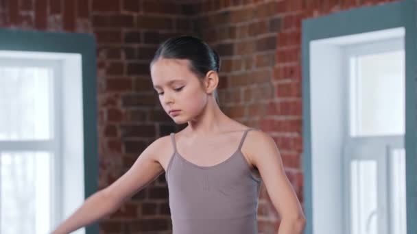 Ein kleines Ballerina-Mädchen trainiert Bewegungen im Studio - Filmmaterial, Video
