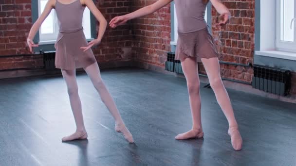Δύο κορίτσια μπαλαρίνες προπονούνται σε σχολή χορού - εκπαιδεύουν την κίνηση των ποδιών - Πλάνα, βίντεο