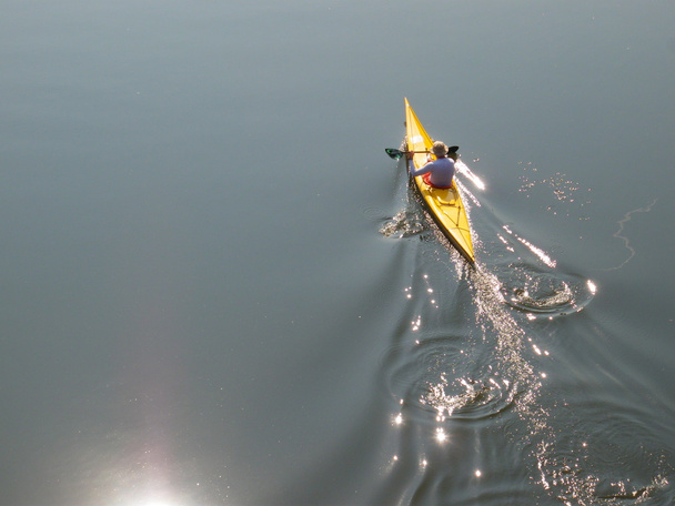 L'homme ramène un kayak de mer jaune
 - Photo, image