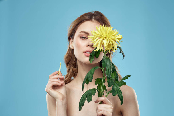 bella donna con fiore giallo vicino al viso sorridente ritagliato vista ritratto di spalle scoperte - Foto, immagini