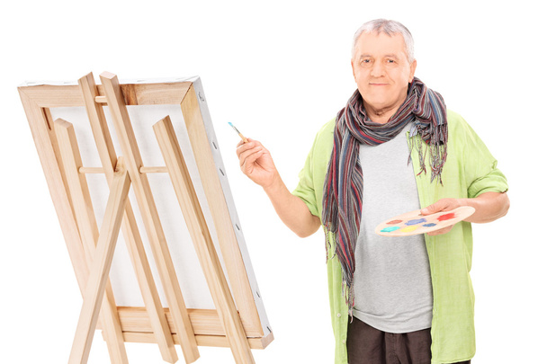 Mature artist drawing on an easel  - Foto, immagini