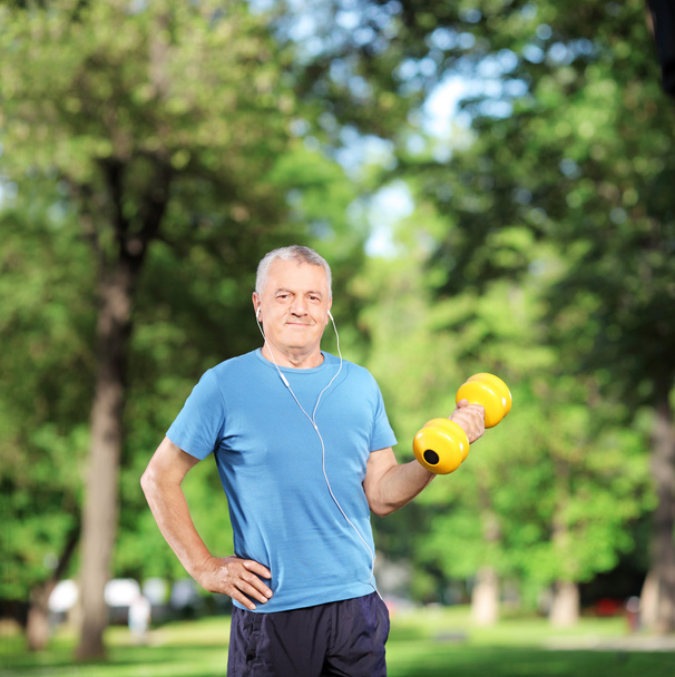 Man exercising with weight in a park - Foto, imagen