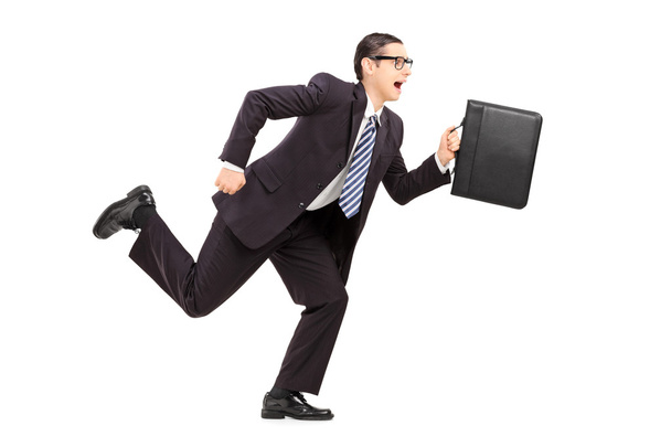 Businessman holding a briefcase and running - Foto, Imagem