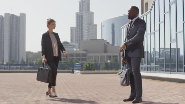 Низькокутний повний знімок з повільною жінкою розумного бізнесу запізнюється на зустріч, в той час як її чоловік афроамериканський бізнес-партнер чекає на неї біля офісу перевірки часу на наручники
 - Кадри, відео