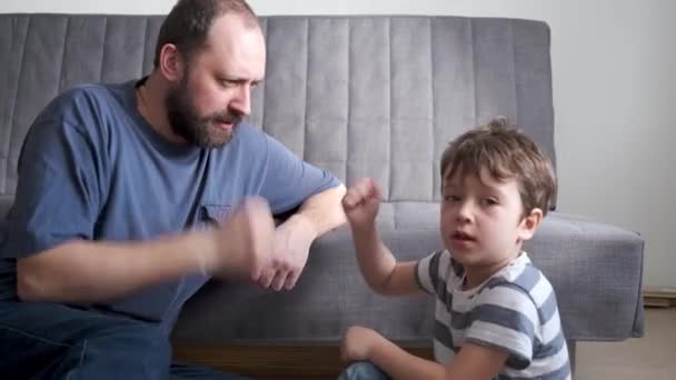 4k. little caucasian son play rock-paper-scissors with father near the couch - Footage, Video
