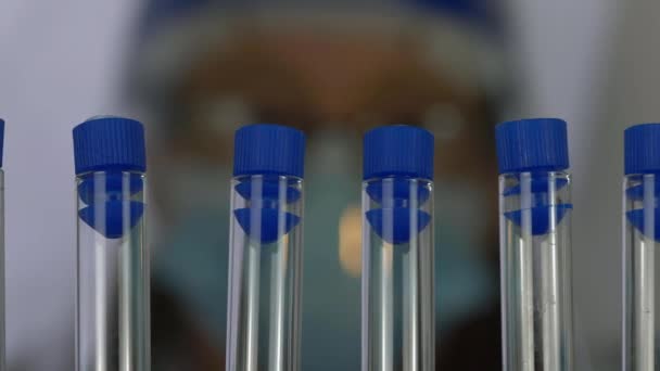 Pessoal médico com fileira de tubos de ensaio em laboratório - Filmagem, Vídeo