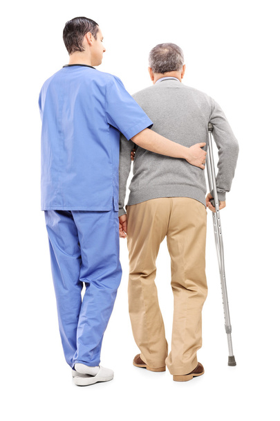 Nurse helping an elderly gentleman - Фото, зображення