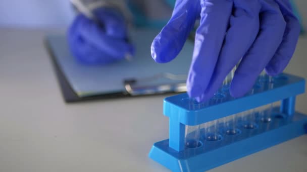 Pessoal médico examina tubo de ensaio em laboratório - Filmagem, Vídeo