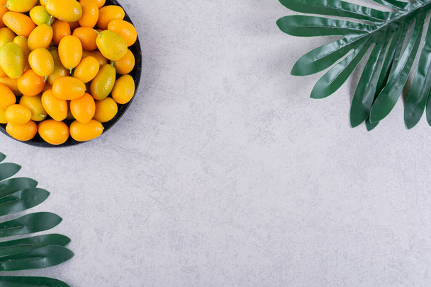 fresh kumquat fruits on kitchen table. free space for text. - Foto, afbeelding