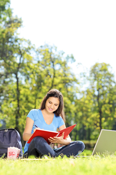 Female student writing in notebook - Zdjęcie, obraz