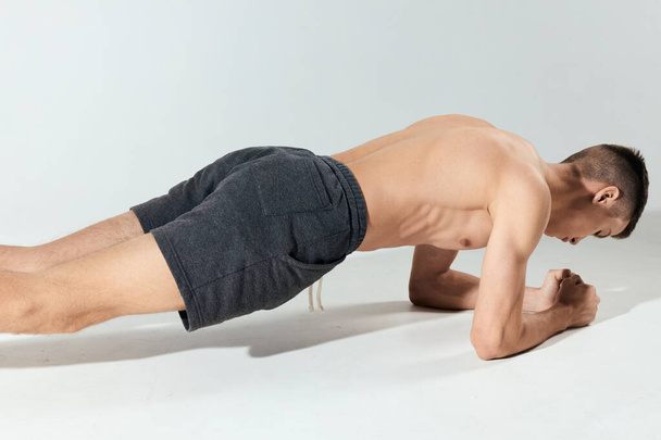 atletische man indoor elleboog push-ups bodybuilder workout - Foto, afbeelding