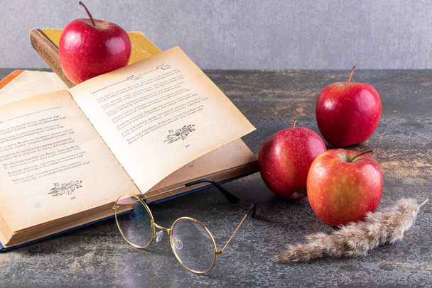 punaiset omenat ja kirja harmaalla pöydällä tausta - Valokuva, kuva