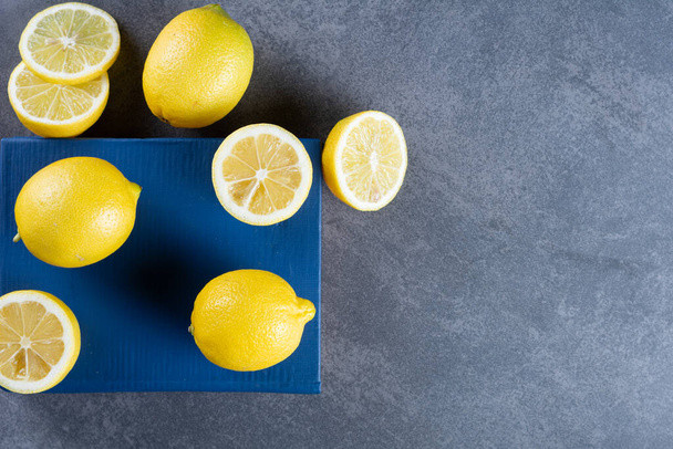 Свежие желтые лимоны на сером фоне   - Фото, изображение