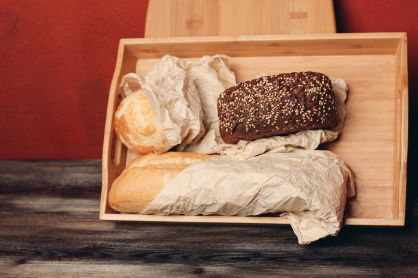 meel producten gebakken goederen op een houten dienblad en een plank op de achtergrond op de tafel - Foto, afbeelding