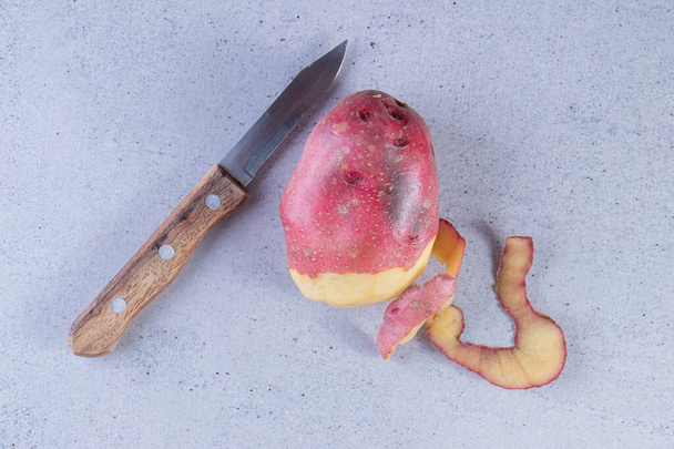 czerwona skórka ziemniaka na szarym tle - Zdjęcie, obraz