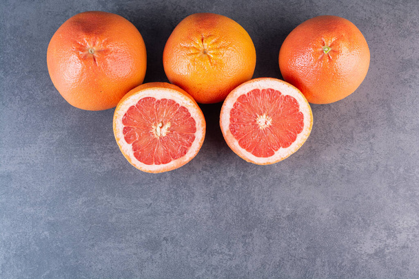 frische reife Grapefruits auf grauem Hintergrund. Ansicht von oben. - Foto, Bild