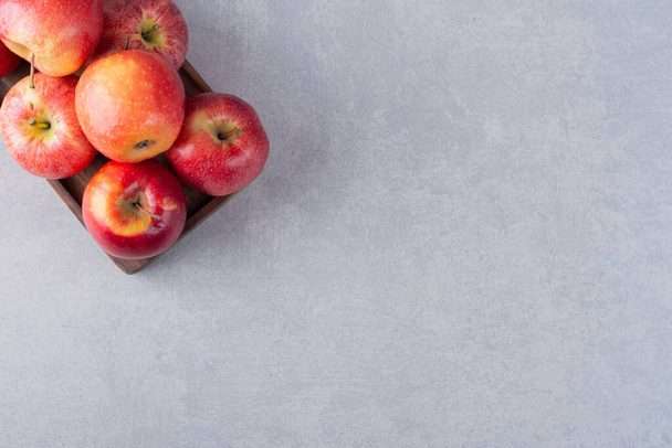 świeże dojrzałe czerwone jabłka na tle stołu kuchennego - Zdjęcie, obraz