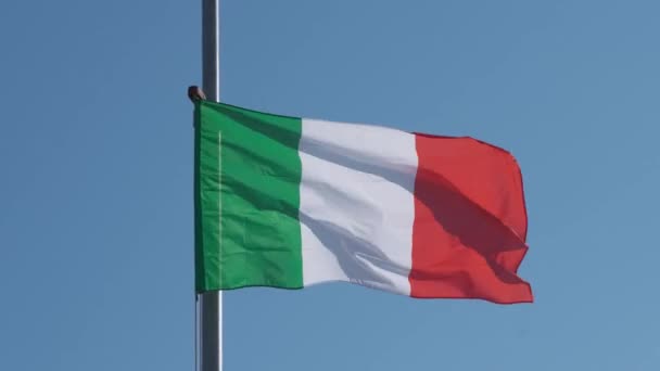 Włoska flaga machająca nad błękitnym niebem - Materiał filmowy, wideo