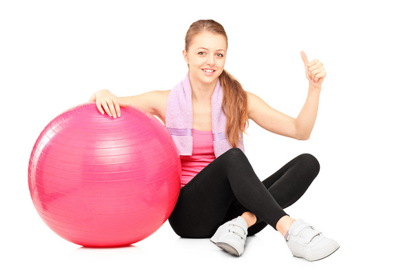 Woman sitting by pilates ball and giving thumb up  - Φωτογραφία, εικόνα