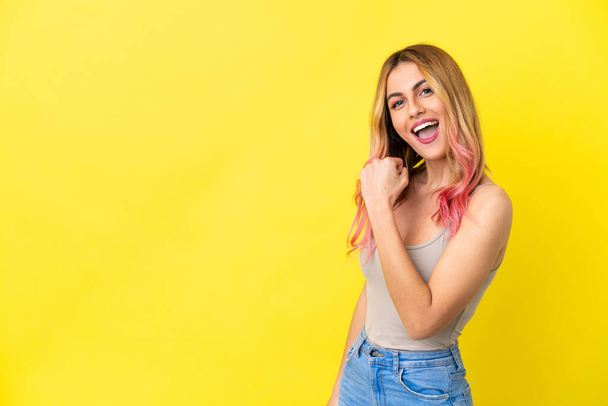 Young woman over isolated yellow background celebrating a victory - Photo, Image