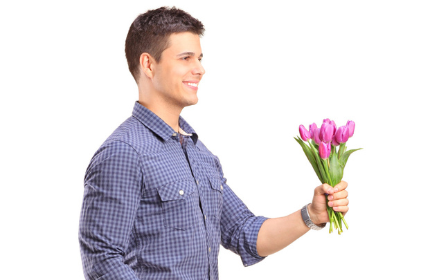 Smiling guy holding flowers - Fotoğraf, Görsel