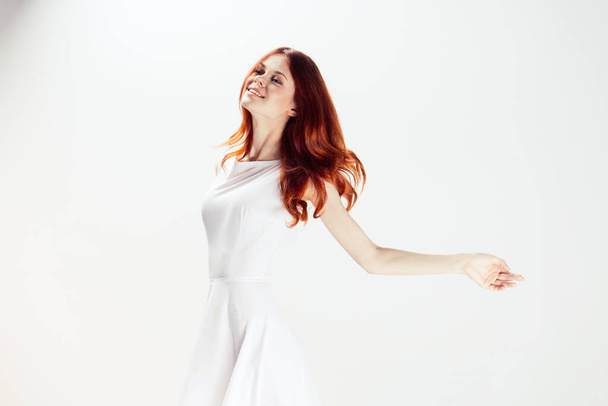 bonita mujer en vestido blanco glamour pelo rojo fondo claro - Foto, Imagen