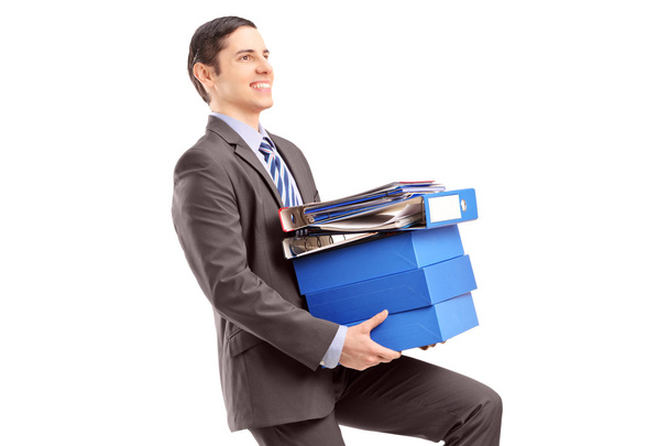 Young businessman carrying heavy folders - Foto, Imagem