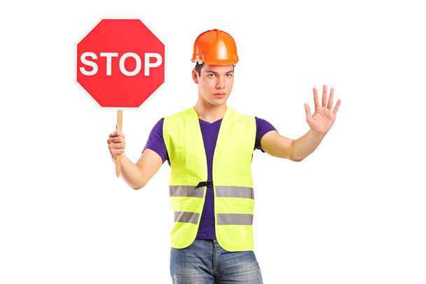 Ein Bauarbeiter hält ein Verkehrsschild - Foto, Bild
