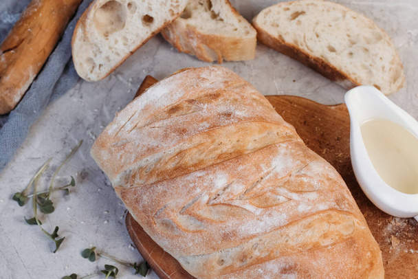 Нарезанный хлеб сиабатта на сером фоне. Итальянский белый хлеб. Вид сверху. - Фото, изображение
