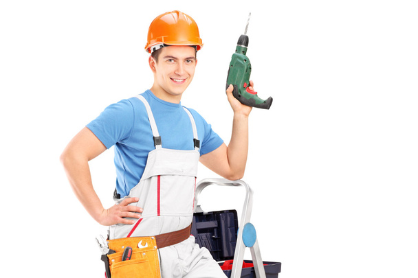 Worker on ladder holding drill - Foto, imagen