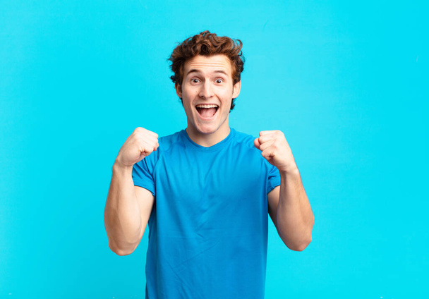 young sport boy feeling shocked, excited and happy, laughing and celebrating success, saying wow! - Foto, afbeelding