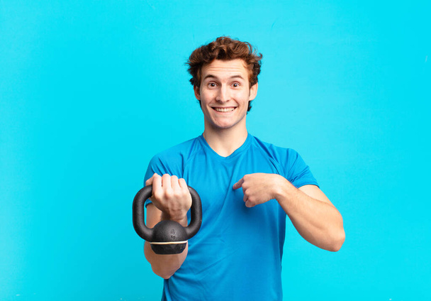 young sport boy feeling happy, surprised and proud, pointing to self with an excited, amazed look. dumbbell concept - Foto, afbeelding
