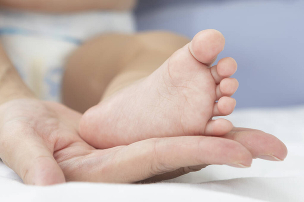 baby foot in the mother hand, close-up - Valokuva, kuva