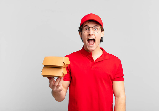 burgers deliver boy shouting aggressively, looking very angry, frustrated, outraged or annoyed, screaming no - Zdjęcie, obraz