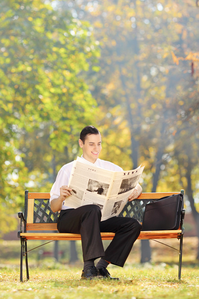 Businessman reading newspaper in park - Фото, зображення