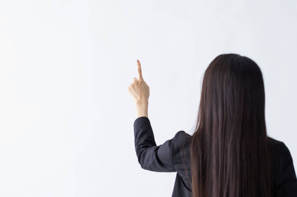rear view of businesswoman pointing by finger - 写真・画像