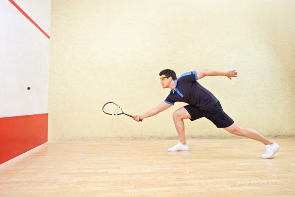 Squash player hiting ball - Фото, зображення