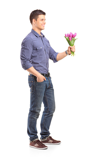 Smiling guy holding flowers - Foto, afbeelding